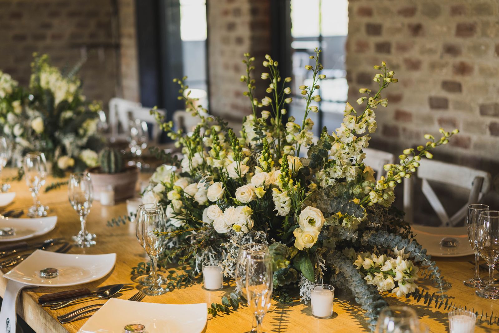 Mesa de recepción con flores blancas y cristalería